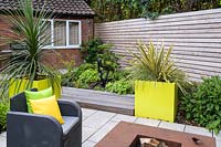 Small Modern Garden with sofa and armchairs around fire pit 