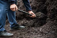 Man shoveling compost with shovel