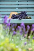 Lavandula - Bunches of dried lavender on a garden seat.