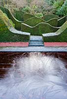 Iced over pool in Reflecting Pool and Hedge garden. Wave-form hedges of Taxus baccata.