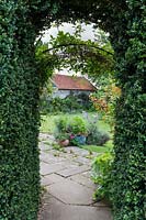 View through the Buxus sempervirens - Box - archway into the main lawn and terrace
