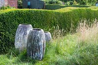 Earthenware pots make a focal point at the edge of the meadow area, next to the 'wave' Buxus - Box hedge 