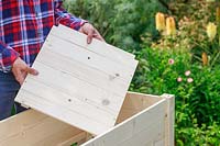Inserting a wooden base into a planter built from a kit