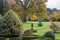 View across small topiary garden to lawn with specimen trees 