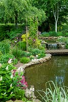 Small waterfall between garden pools, with foot bridge and border planting including Maianthemum racemosum - Soloman's Plume - Ferns, Grasses and Ceonothus - Open Gardens Day, Bures, Suffolk