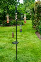 Well stocked bird feeding station in lawn - Open Gardens Day, Bures, Suffolk