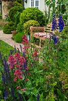 Border containing Salvia, Valerian, Campions, Verbena and Delphiniums with garden seat, path and shrubs beyond - Open Gardens Day, Earl Stonham, Suffolk
