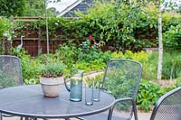View of suburban garden from metal dining table and chairs