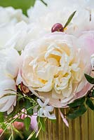 White roses, peonies and jasmine in gold vase