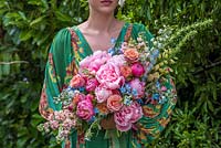 Girl holding large boho bouquet with peonies, roses, foxgloves, stock and delphiniums
