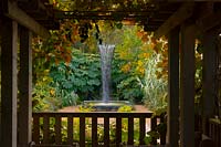 Pergola overlooking water feature and planting
