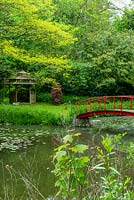 Red bridge over lake with Chinese pagoda style gazebo beyond - Open Gardens Day, Nacton, Suffolk
