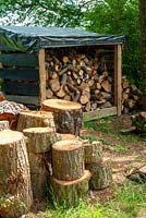 Large logs stacked near woodstore - Open Gardens Day, Bromeswell, Suffolk