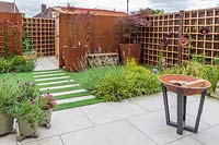 Suburban garden with corten steel screen screens, artificial grass and paving