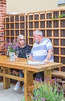 Garden owners sat by wooden dining table