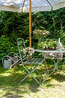 Vintage garden chairs and table under shade of parasol
