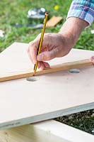 Man using ruler to mark where to cut to create the handle