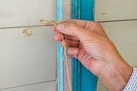 Woman attaching string to the hooks
