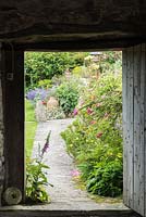 View through barn door into the cottage garden in June