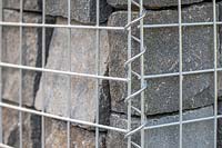 Close up detail of granite blocks within gabion basket cage. 