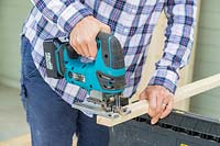 Using a cordless jigsaw to cut timber battens to size