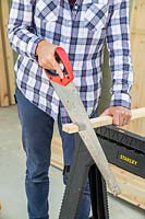 Using a saw to cut timber battens to size