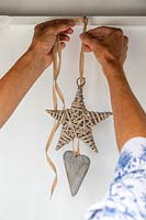 Decorating shed interior by hanging up a wicker star and heart