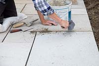 Man pointing newly laid square patio. 