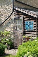 Wooden leanto shed with vintage metal sign