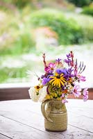A simple posy of flowers in a jug at Am Brook Meadow, Devon in August. 