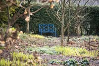 Blue painted metal bench at the Old Rectory, Netherbury, UK. 