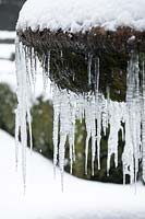 Frozen water - icicles hanging from classic fountain