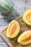 Melon 'Irina' quartered to reveal the fresh and seeds inside