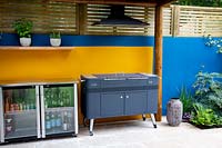 Outdoor kitchen with covered barbecue and fridge