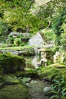 An Edwardian Japanese-style garden, view of stone lanterns, mossy and water 