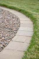 Path edge made from square pavers, edging between lawn and gravel path