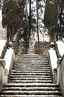 Stone steps leading to statue covered on snow
