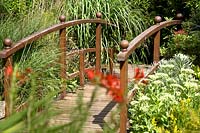 Wooden bridge surrounded by mixed planting