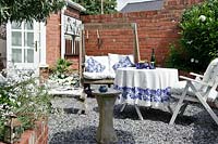 White and blue themed seating area with swing bench and wooden seats