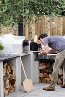 Man baking pizza in pizza oven