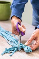 Woman using sissors to trim excess off fabric cord