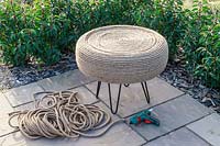 Completed tyre table covered in jute rope in circular pattern on patio