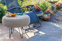 Rope covered tyre table on patio with reclining chair and decorative tyre planter