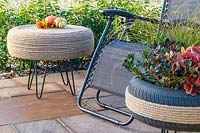 Rope covered tyre table on patio with reclining chair and decorative tyre planter