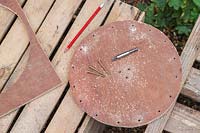 Wooden disk with drilled countersunk holes for fixing the disk to the wooden post