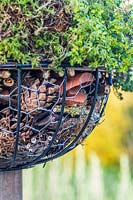 Detail of finished globe insect hotel mounted on a post. 