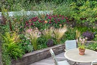 Raised beds planted with sun-loving, wildlife-friendly perennials and grasses in London garden. 
