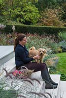 Calista Dobson sitting on the terrace steps with Barney, a Norfolk terrier.