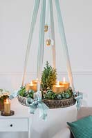 Hanging advent arrangement with gold candles, miniature christmas tree and Eucalyptus and Hebe foliage