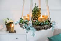 Hanging advent arrangement with gold candles, miniature christmas tree and Eucalyptus and Hebe foliage